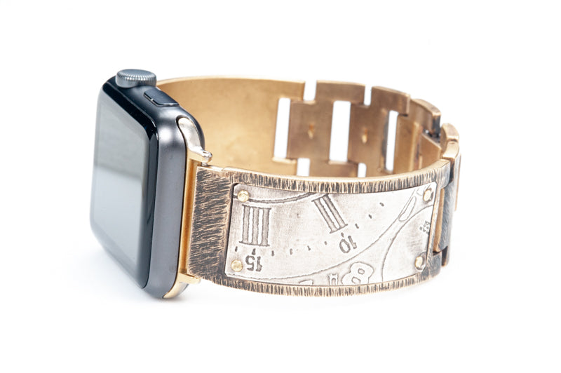 Close up of the sterling silver Apple watch band on the Tristan. Detail of the Roman numerals embossed into the silver from the vintage watch dials. Apple watch facing left.