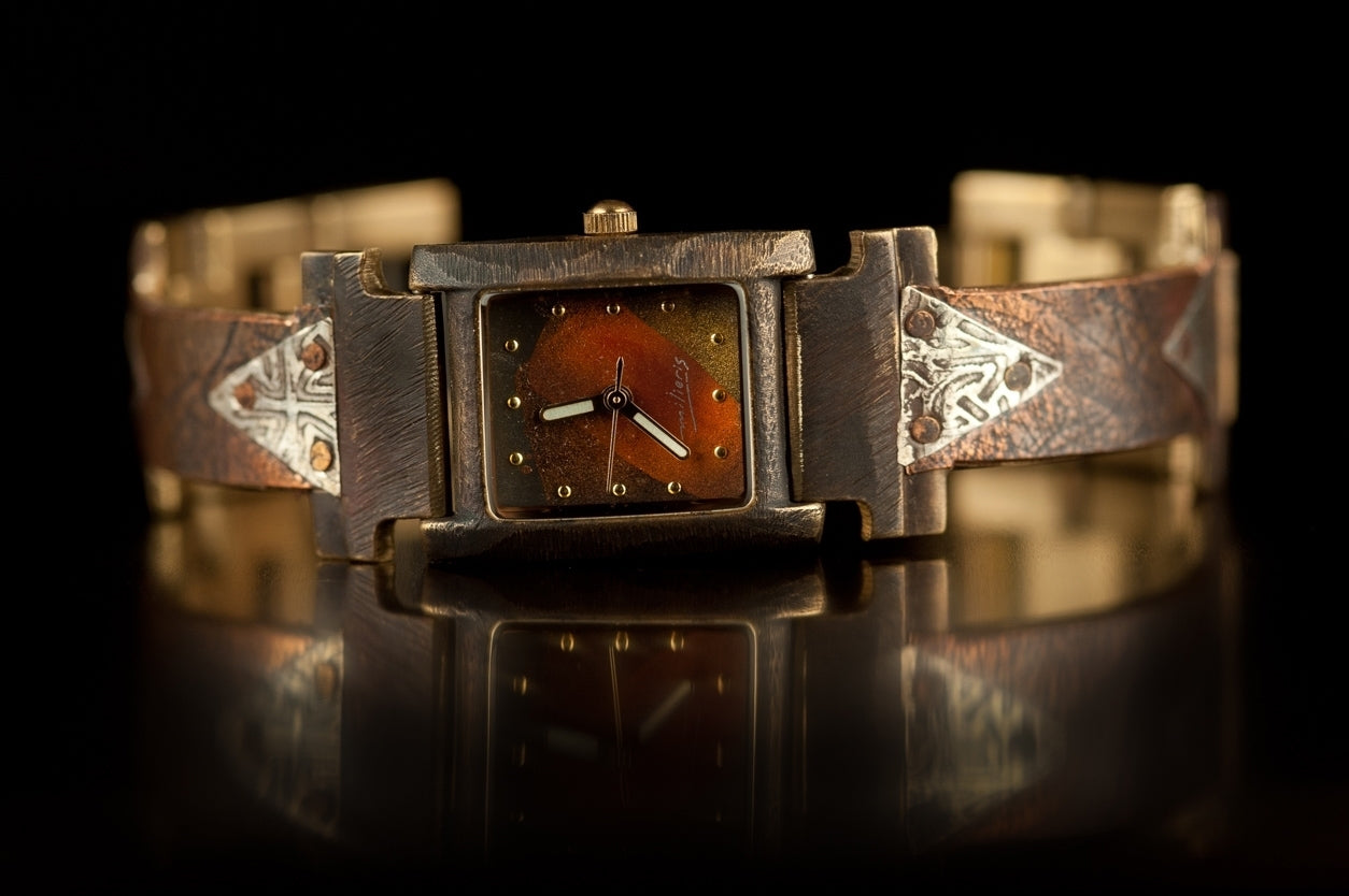 The Ponte Vecchio watch in copper and silver, facing front on a black background. While the white background makes for a clearer product photo, the black background brings out the richness of the copper, in some ways giving a truer image of the watch on your wrist.