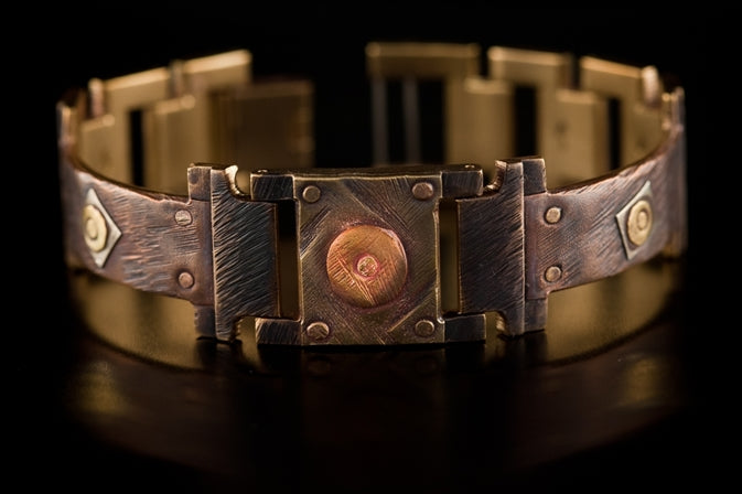 The Cornett handcrafted copper bracelet from WATCHCRAFT by Eduardo Milieris. A brushed copper band is embellished with diamond-shaped brass and silver beads.