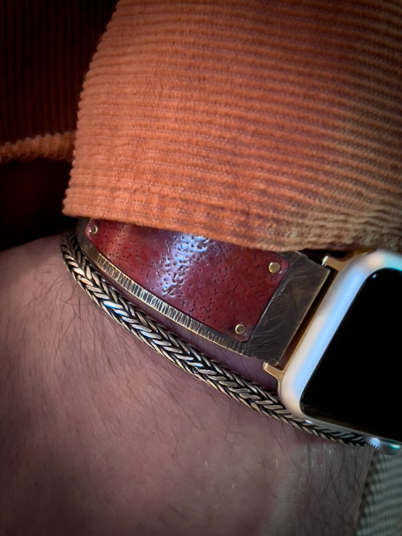 Viola Apple Watch band in red copper on Bruno's wrist. You can see part of Bruno's orange corduroy shirt and and a silver bracelet.